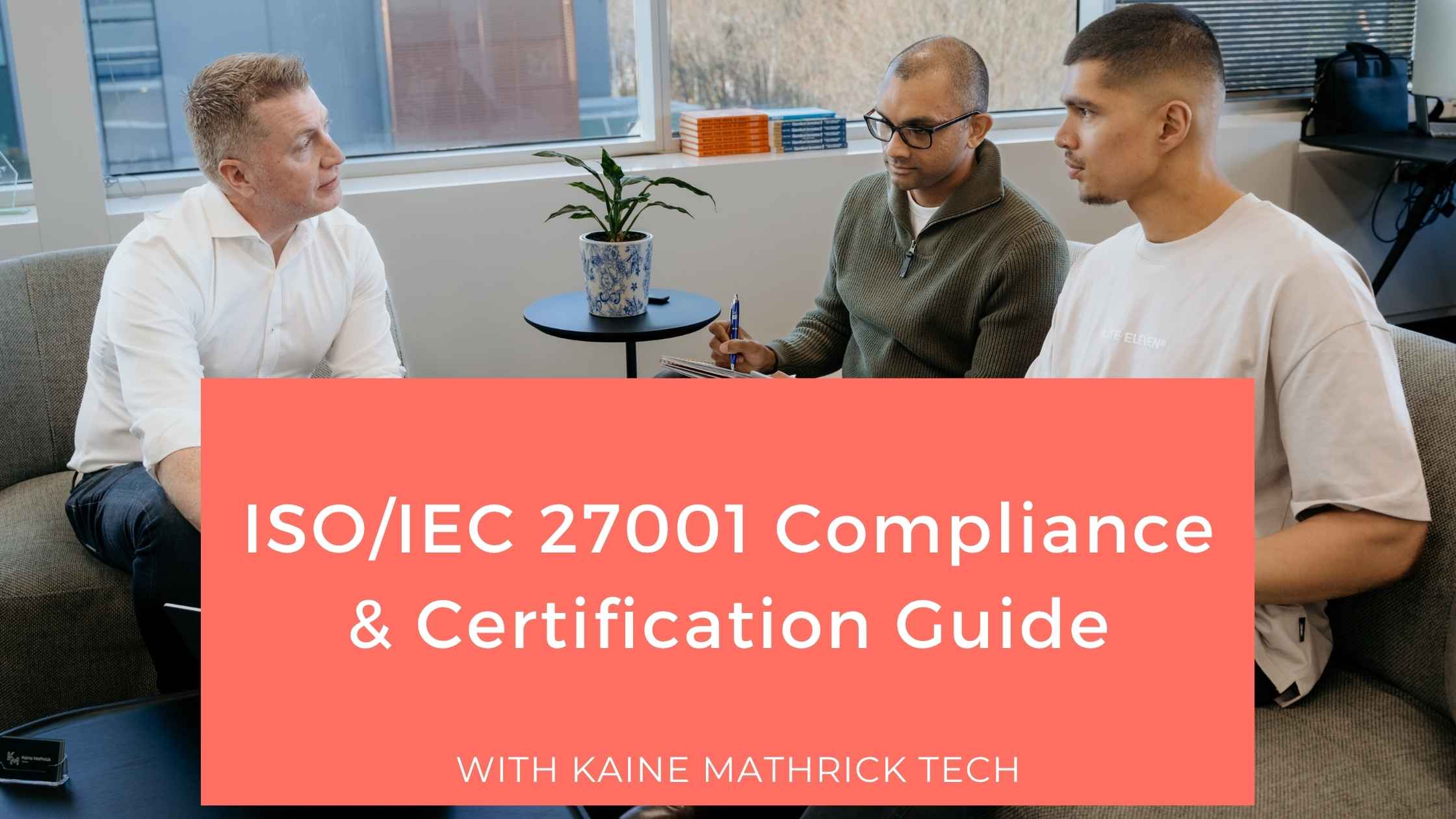 Team discussing ISO/IEC 27001 compliance and information security certification in an office setting.